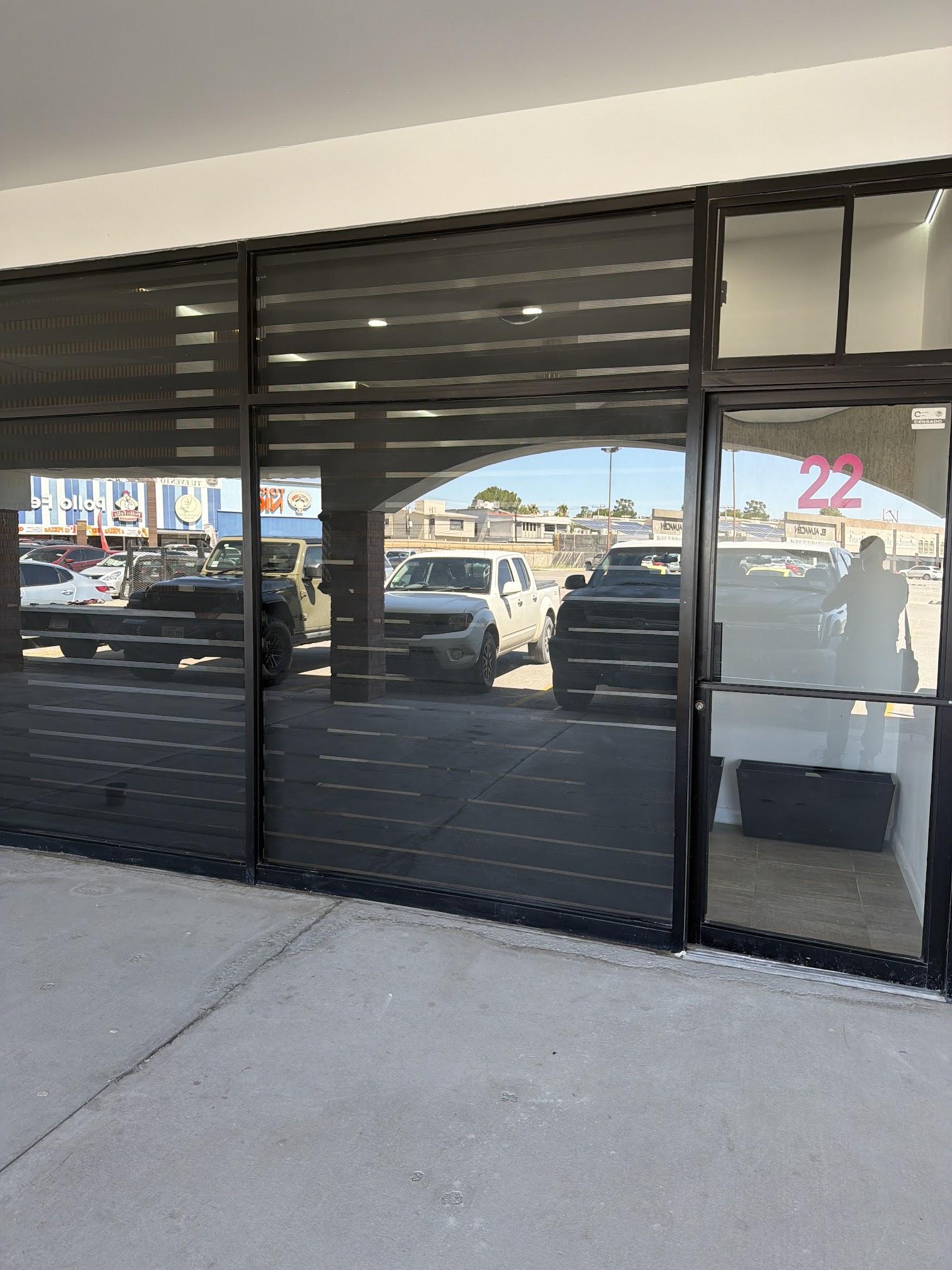Fachada del Local 22 en Plaza Primavera, con el número 22 en la puerta de cristal